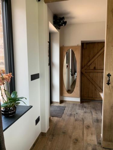 a hallway with a sliding barn door and a refrigerator at Vakantiewoning 't Rysselhof in Kaprijke