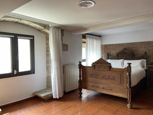 a bedroom with a wooden bed and a window at Musikarte Etxea in Estavillo
