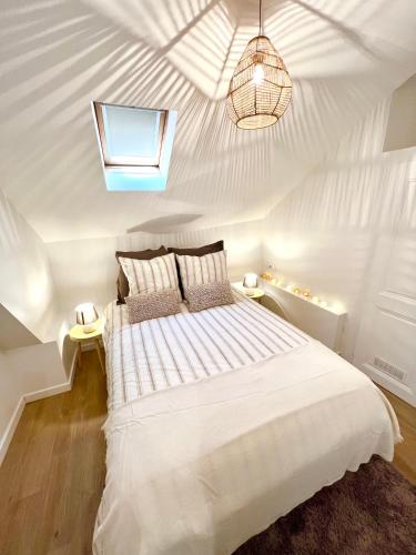 - une chambre avec un lit blanc et un plafond dans l'établissement L'étoile Grenobloise, à Grenoble