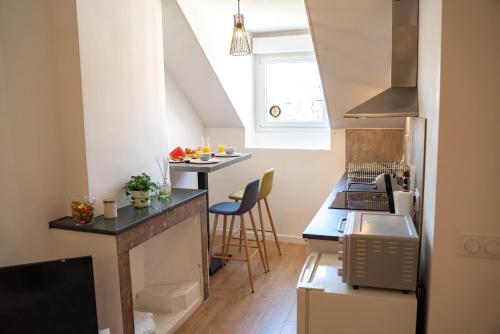 - une petite cuisine avec un comptoir et une table dans l'établissement L'étoile Grenobloise, à Grenoble