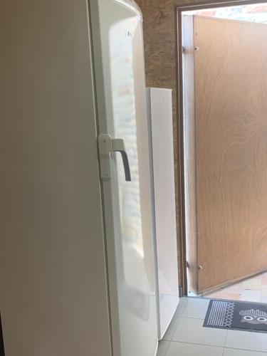 a white refrigerator with a door in a kitchen at Vakantiewoning 't Rysselhof in Kaprijke