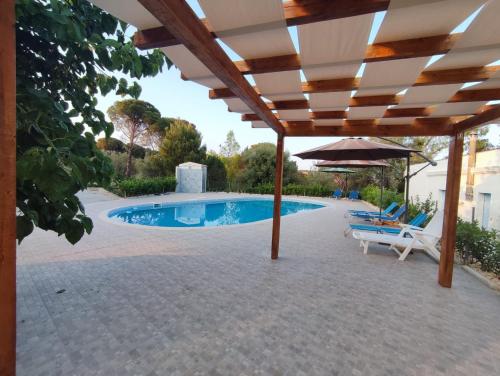 a patio with a pergola and a swimming pool at Cristian Rooms in Avola
