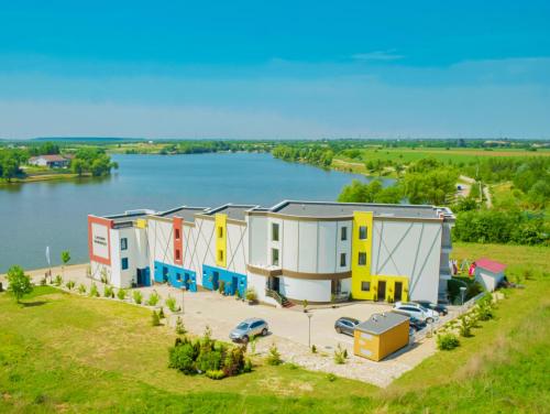 z góry widok na budynek obok jeziora w obiekcie Snagov Lakeview Residences w mieście Tîncăbeşti