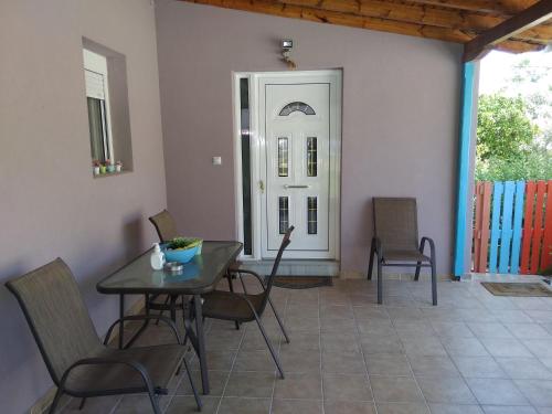 uma sala de jantar com uma mesa e cadeiras e uma porta em Valta's Room em Paleros