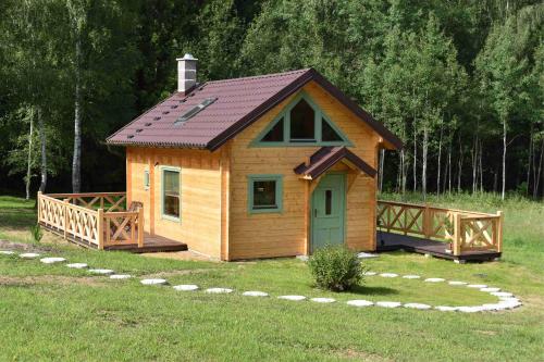 una pequeña cabaña de madera en un campo de hierba en Ogród Shinrin Yoku (Haru) Odpoczynek w Lesie en Srokowo