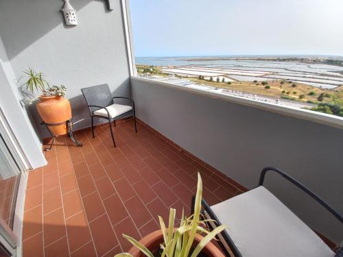 a balcony with two chairs and a view of a runway at Sea View urban apartment in Faro
