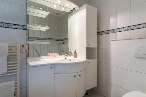 bagno bianco con lavandino e specchio di Inner Stillness Wellness Retreat ad Albergen