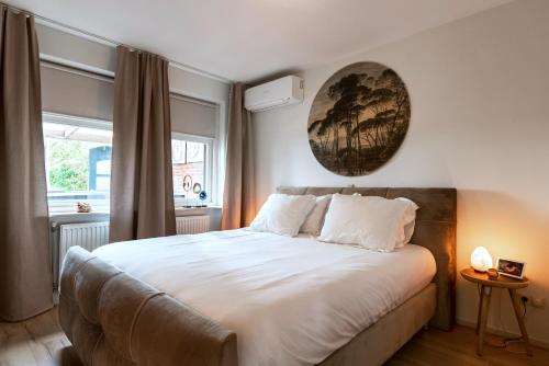 a bedroom with a large white bed with a window at Inner Stillness Wellness Retreat in Albergen