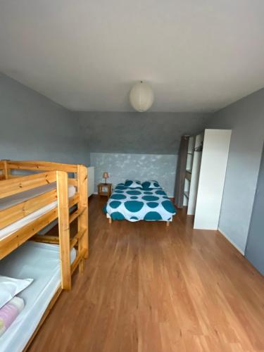 a bedroom with two bunk beds and a wooden floor at Maeva in Pontorson
