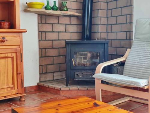 a fireplace in a living room with a chair and a stove at Apartamento rural el Vidre VT-42035-CS in Vistabella del Maestrazgo