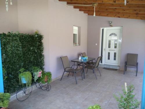 a patio with a table and chairs next to a wall at Valta's Room 2 in Paleros