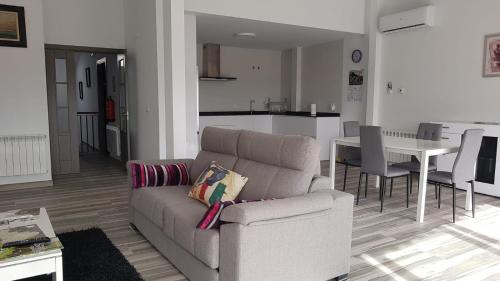 a living room with a couch and a table and a kitchen at Apartamento Buenavista in Villamiel