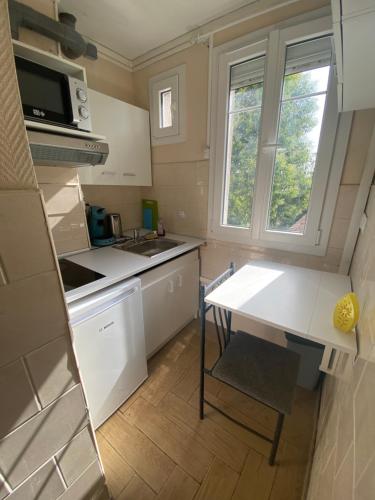 a small kitchen with a table and a sink at RENT APPART - La Garenne Colombes in La Garenne-Colombes