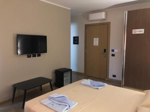 a hotel room with two beds and a flat screen tv at Rittson - Boutique Hotel in Vlorë