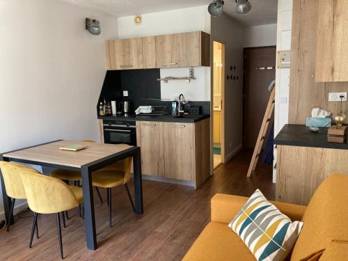 une cuisine et un salon avec une table et des chaises dans l'établissement Cauterets : le meilleur du confort en famille, à Cauterets