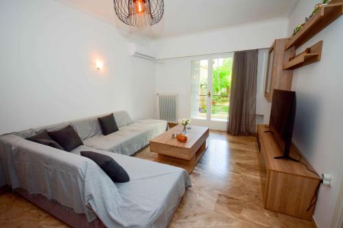 ein Wohnzimmer mit einem Sofa und einem Tisch in der Unterkunft Filoxenia Apartment Athens in Athen