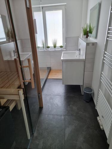 a small bathroom with a sink and a window at Wohnungen mit direktem Meerblick in Laboe