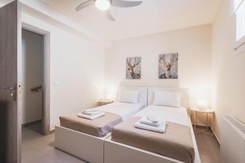 1 dormitorio blanco con 2 camas y ventana en ONAR PORTO RAFTI, en Porto Rafti