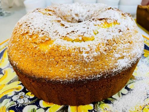 a bundt cake with powdered sugar on a plate at Hotel Villa Serena in Castrocaro Terme