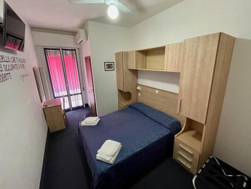 a small bedroom with a blue bed and a wooden cabinet at Hotel Villa Serena in Castrocaro Terme