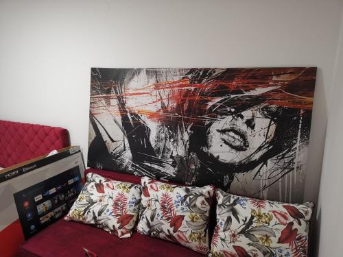 a wall with a painting above a couch with pillows at The Silken Symphony in Niš