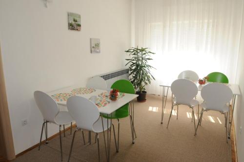 jadalnia ze stołem i białymi krzesłami w obiekcie Rooms Stella w mieście Sesvete