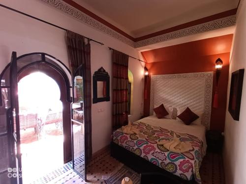 1 dormitorio con cama y puerta abovedada en Riad Zagouda en Marrakech