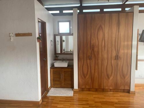 a bathroom with a wooden door and a sink at Quito Downtown View Point Studio in Quito
