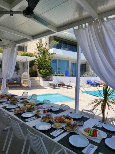stół z jedzeniem obok basenu w obiekcie Made of Blue luxury suites collection w Retimnie