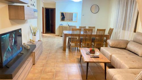 - un salon avec un canapé, une télévision et une table dans l'établissement COMILLAS Chalet La Higuera, à Casasola