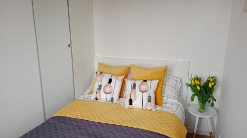 1 dormitorio con 1 cama con almohadas amarillas en APARTAMENT DWUPOKOJOWY en Ostrowiec Świętokrzyski