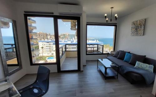 salon z kanapą i widokiem na ocean w obiekcie Aloha Beach Vibe w mieście Benalmádena