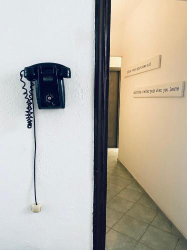 a phone on the side of a wall next to a door at Black Market Hotel in Ischia