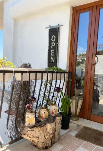 a balcony with potted plants and a sign on a building at Black Market Hotel in Ischia