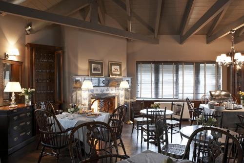a dining room with tables and chairs and a fireplace at Aegli Arachova in Arachova
