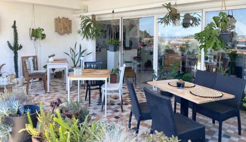 a patio with tables and chairs and potted plants at Black Market Hotel in Ischia