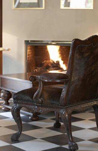 a leather chair sitting in front of a fireplace at Aegli Arachova in Arachova