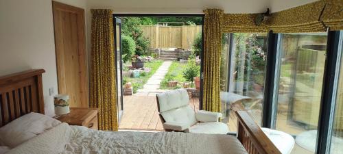 een slaapkamer met uitzicht op een patio met een stoel bij Stonehaven 2 Bedroom Seaside Cottage with Garden in Stonehaven