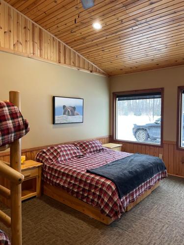 um quarto com uma cama grande e uma janela em Timberwolf Lodge em Manistique