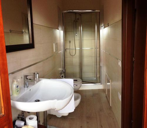 a bathroom with a white sink and a toilet at Bed & Breakfast La Casa Antica in Macomer