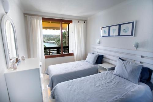 a hotel room with two beds and a window at Doñana Apartamento Sunset first line to the beach in Patalavaca