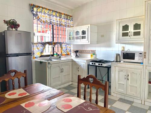 a kitchen with white cabinets and a table and chairs at Casa Siloe in Campeche