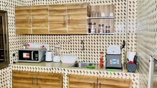 una pequeña cocina con fregadero y microondas en JIKKE Appartement, en Dakar