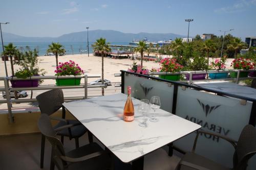 a bottle of wine sitting on a table on a balcony with a beach at Veranda Boutique Hotel in Vlorë