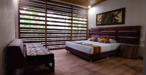 a bedroom with a bed and a chair and a window at Reserva Yavary Tucano in Leticia