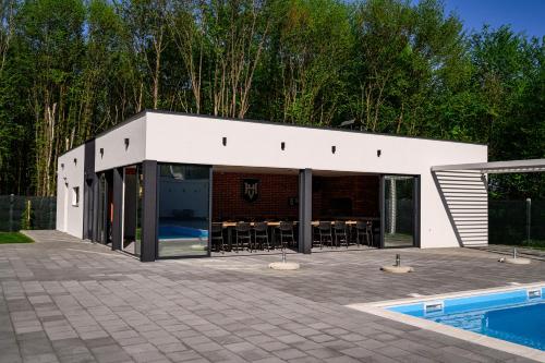 a building with a swimming pool and a patio at Villa Hills in Bijeljina