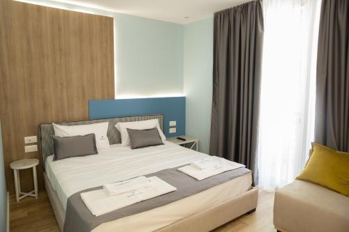 a bedroom with a large bed and a window at Veranda Boutique Hotel in Vlorë