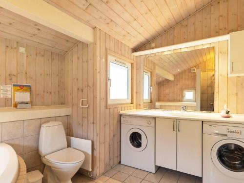 a bathroom with a toilet a sink and a washing machine at 6 person holiday home in Bindslev-By Traum in Stabæk