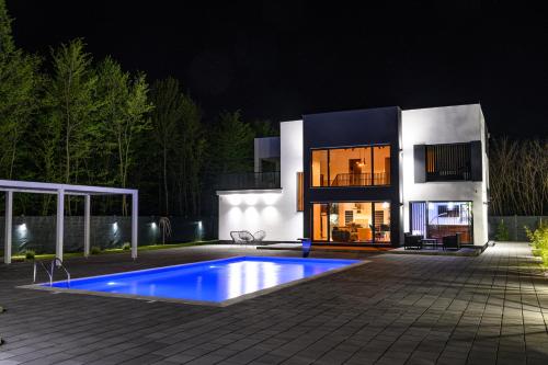 a house with a swimming pool in front of it at night at Villa Hills in Bijeljina