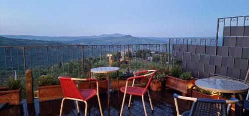 a patio with two tables and chairs on a balcony at B&B La Castellina in Abbadia San Salvatore